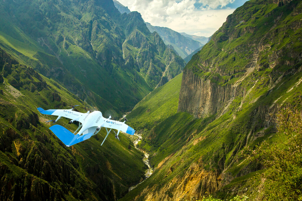 Photo of a UAV flying through a mountainous terrain.