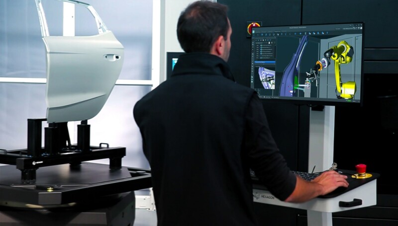 Operator of Hexagon PRESTO at the workstation looking at digital representation of the robotic cell.