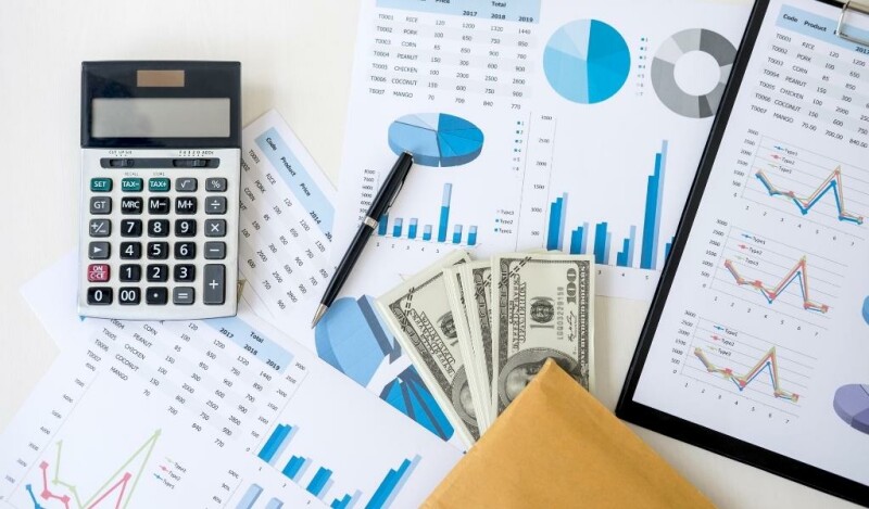 Assortment of work documents, a pen, calculator, and cash