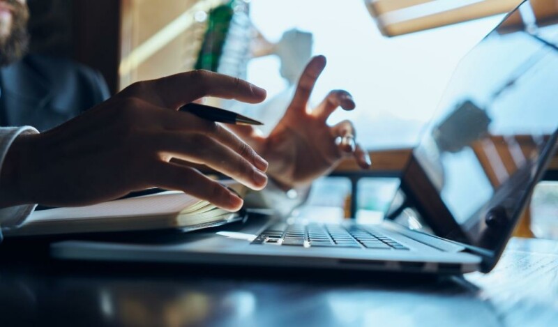 Person working at computer with body language indicating confusion or realization