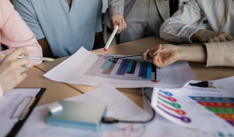 Two colleagues analyzing a chart on a sheet of paper