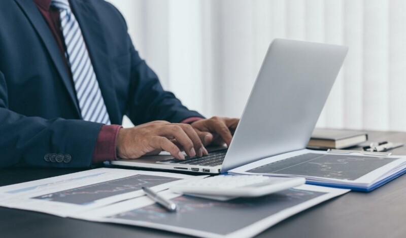 Man sitting at his desk with his laptop open and notes to his side