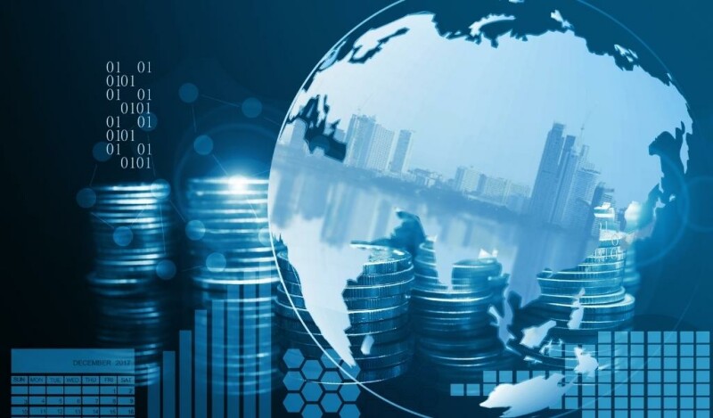 Abstract image of global earth with a cityscape silhouette in the background accompanied by stacked coins and charts