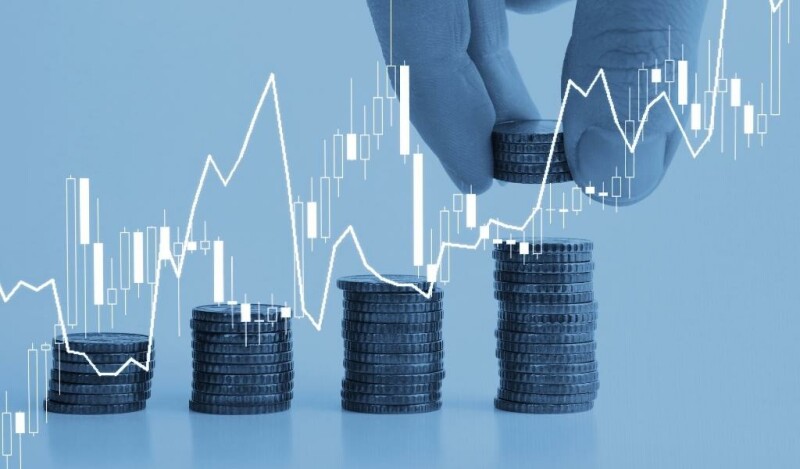 Stacks of coins becoming larger left to right with a hand adding to the stack farthest right. A chart is overlaid to show growth.