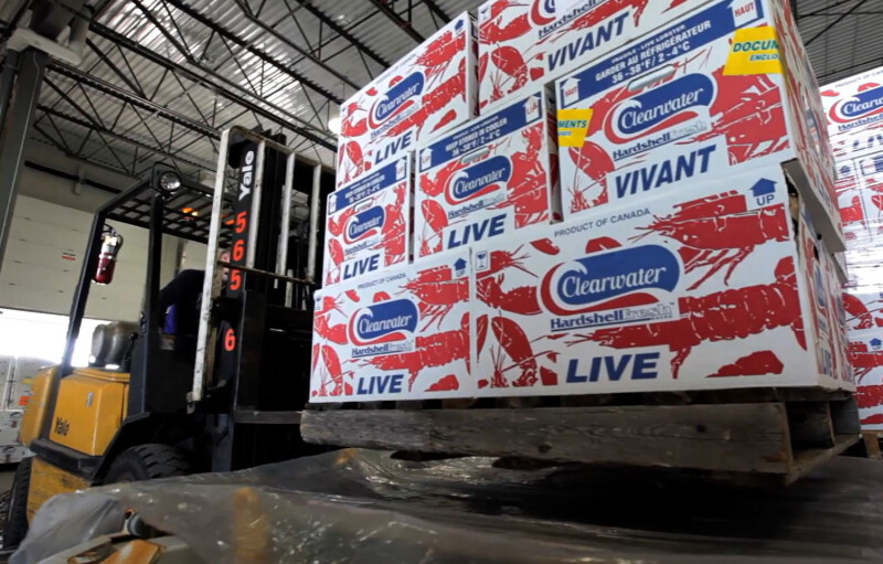 A pallet with Clearwater Seafoods packages on it being lifted by a forklift