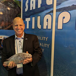 Ron Risher posing with one of the company's tilapia during Seafood Expo Asia