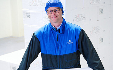 Salmon Evolution employee holding a box of salmon.