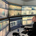An Ice Fish Farm worker observing salmon farms on computer screens.