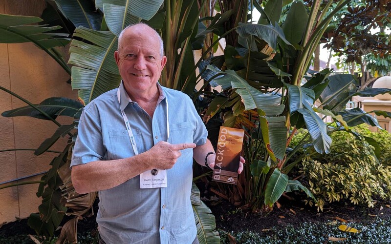 Keith Singleton showing off a pamphlet detailing Alaskan Leader Seafoods' miso black cod.