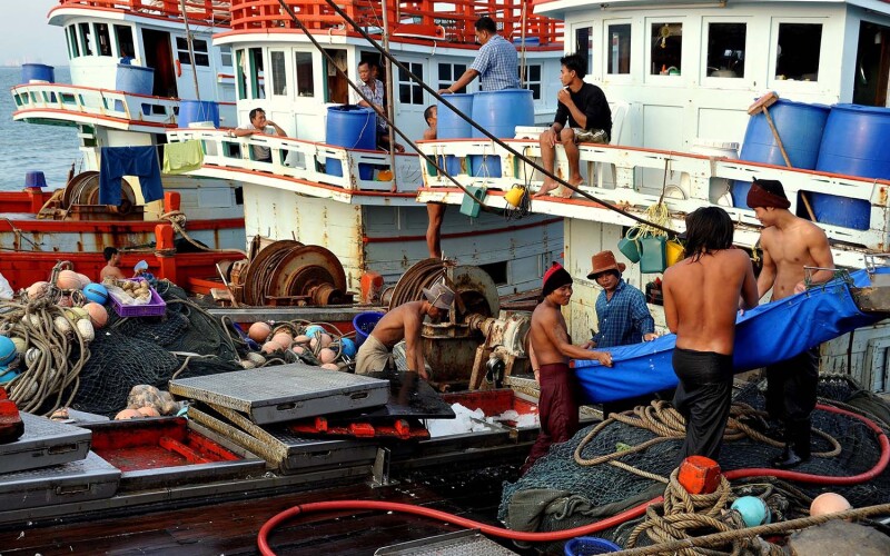 Workers load ice onto fishing vessels in Thailand