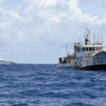U.S. Coast Guard vessel Cutter Harriet Lane seen in the distance of a fishing vessel in the South Pacific Ocean