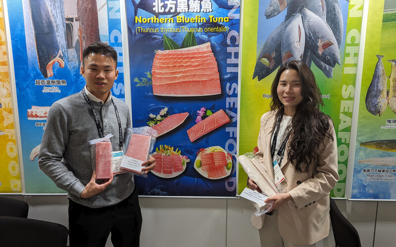 Wen Chi Seafoods employees pose with examples of their products in their booth at Seafood Expo North America