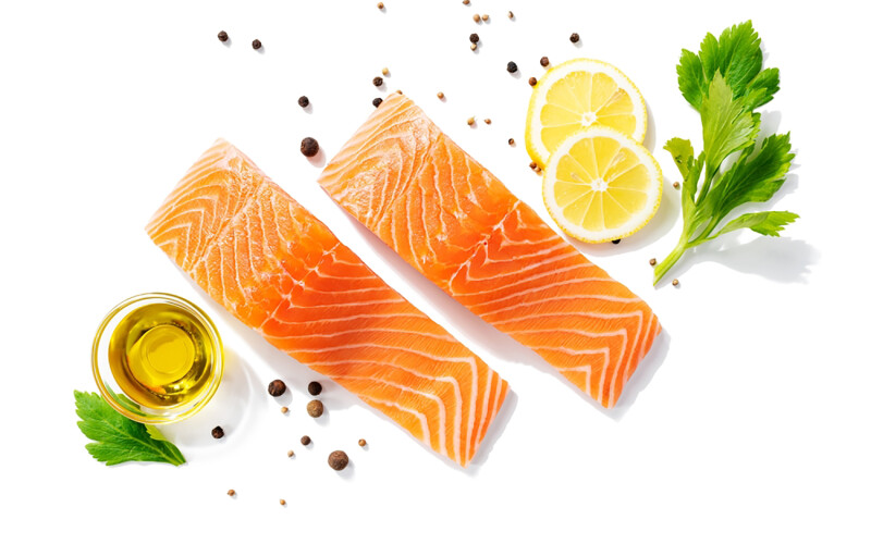 Salmon fillets surrounded by lemon wedges and granishes