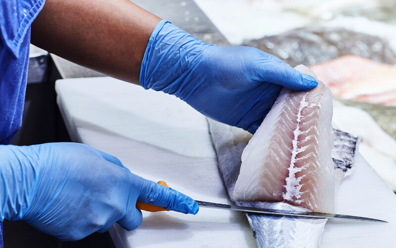 A Norcod employee processing a piece of cod