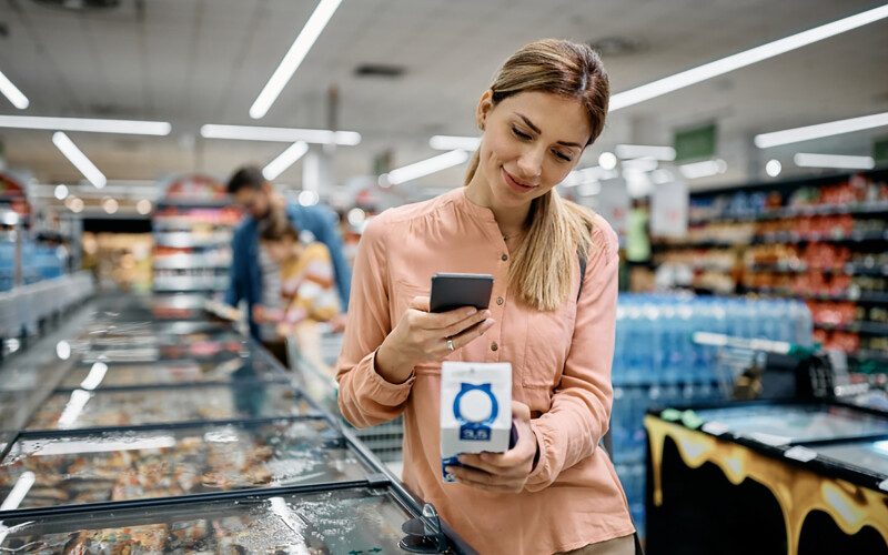 A woman scanning a QR code at a grocery store