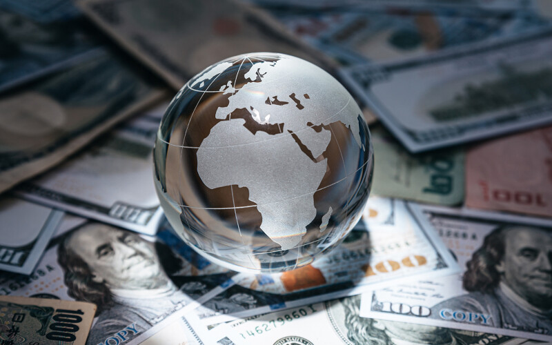 A stock photo of a glass globe on a pile of money
