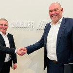 Grieg Director Piotr Wingaard and BAADER Norway Vice President of Sales Modulf Barstad shake hands at BAADER's booth in Barcelona, Spain