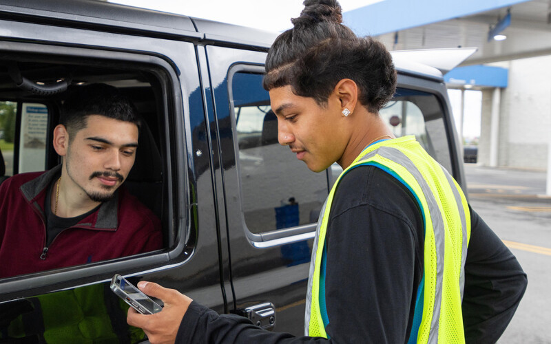 A Walmart employee loading groceries into a customer's car