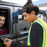 A Walmart employee loading groceries into a customer's car