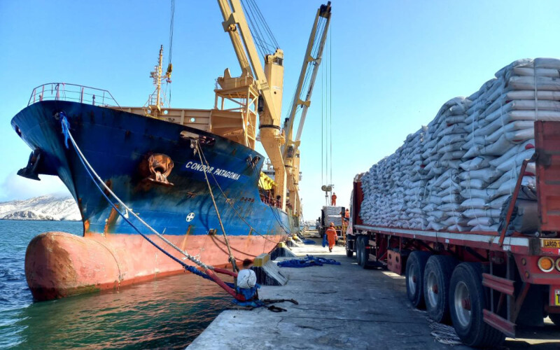 An Austral Group cargo vessel unloading bags of fishmeal onto trucks